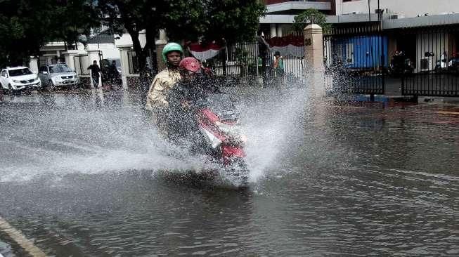 Beberapa kendaraan tampak melintasi jalanan yang tergenang air di Jalan Agus Salim, kawasan Menteng, Jakarta Pusat, Selasa (30/8/2016). [Suara.com/Oke Atmaja]