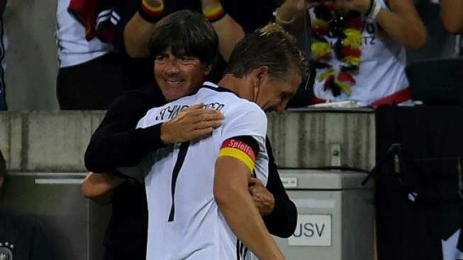 Pelatih Jerman Joachim Loew memeluk Bastian Schweinsteiger usai laga terakhirnya bersama Jerman [Reuters]