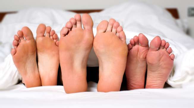 Ilustrasi kaki di atas ranjang. (Shutterstock)