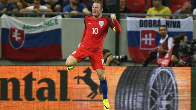 Kapten Tim Inggris Wayne Rooney merayakan kemenangan skuatnya. JOE KLAMAR / AFP