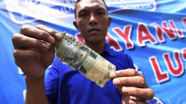Sejumlah warga antre untuk menukarkan uang rusak dengan uang baru di mobil Layanan Kas Keliling Bank Indonesia di kawasan perbelanjaan Lokasari, Jakarta, Selasa (6/9).