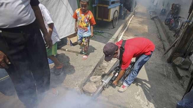 Petugas melakukan pengasapan (fogging) untuk memutus mata rantai berkembangnya nyamuk, di perumahan padat penduduk di kawasan Pademangan, Jakarta, Sabtu (10/9/2016). [Suara.com/Kurniawan Mas'ud]