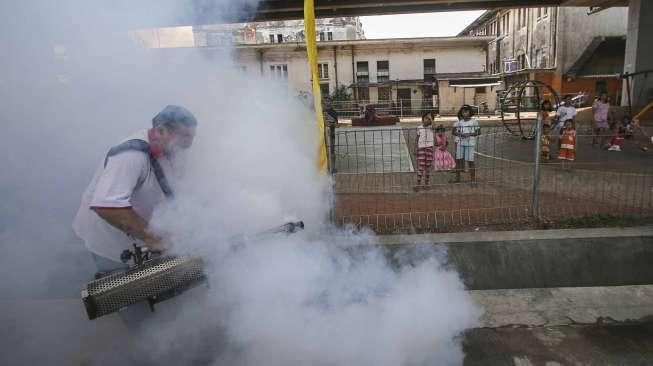 Petugas melakukan pengasapan (fogging) untuk memutus mata rantai berkembangnya nyamuk, di perumahan padat penduduk di kawasan Pademangan, Jakarta, Sabtu (10/9/2016). [Suara.com/Kurniawan Mas'ud]