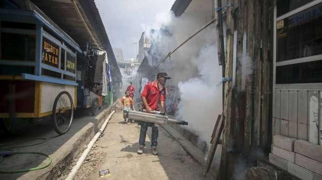 Petugas melakukan pengasapan (fogging) untuk memutus mata rantai berkembangnya nyamuk, di perumahan padat penduduk di kawasan Pademangan, Jakarta, Sabtu (10/9/2016). [Suara.com/Kurniawan Mas'ud]