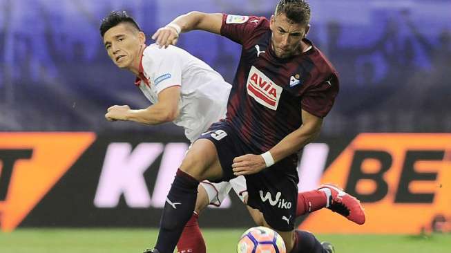 Pemain Eibard Sergi Enrich mengambil bola dari pemain Sevilla. ANDER GILLENEA / AFP