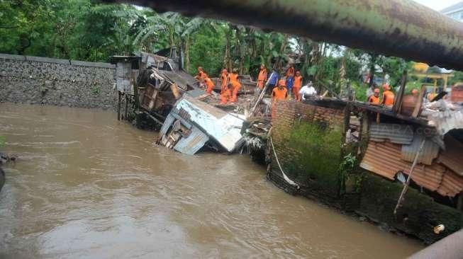 Petugas melakukan pembongkaran bangunan semipermanen di bantaran Kali Krukut, Jakarta Selatan, Kamis (13/10/2016). [Suara.com/Oke Atmaja]