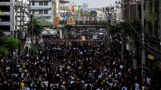 Ribuan orang tampak bergerak di jalanan Bangkok, usai prosesi dibawanya jenazah Raja Thailand, Bhumibol Adulyadej, dari Rumah Sakit Siriraj. [Manan Vatsyayana/AFP]