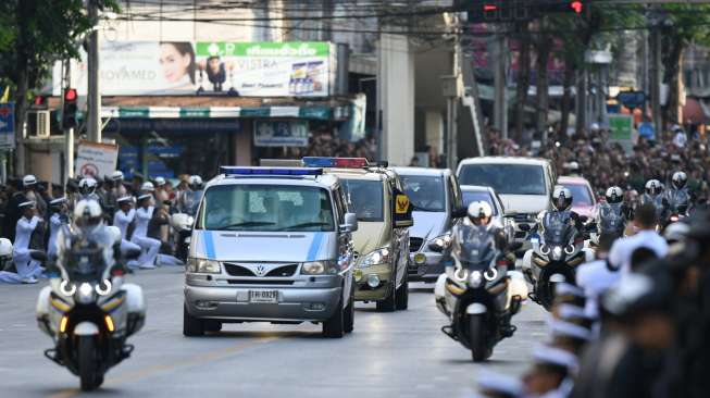 Iring-iringan kendaraan yang membawa jenazah Raja Thailand, Bhumibol Adulyadej, tampak di jalanan menuju Istana Kerajaan di Bangkok, Jumat (14/10/2016). [Manan Vatsyayana/AFP]