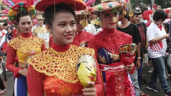 Sejumlah perempuan mengenakan busana penari topeng dalam acara Hajatan Bank DKI saat Car Free Day (CFD) di kawasan Bundaran HI, Jakarta, Minggu (16/10/2016). [Suara.com/Oke Atmaja]