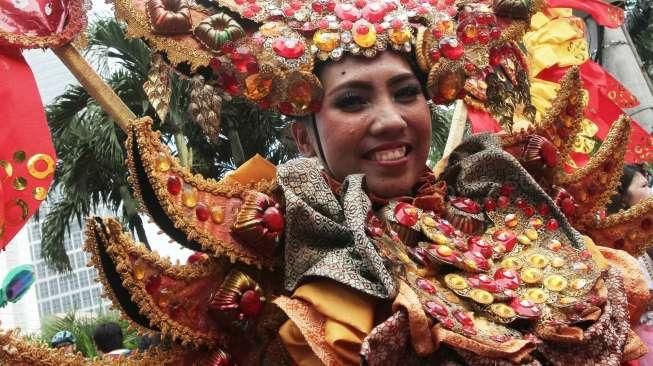 Sejumlah perempuan mengenakan busana penari topeng dalam acara Hajatan Bank DKI saat Car Free Day (CFD) di kawasan Bundaran HI, Jakarta, Minggu (16/10/2016). [Suara.com/Oke Atmaja]