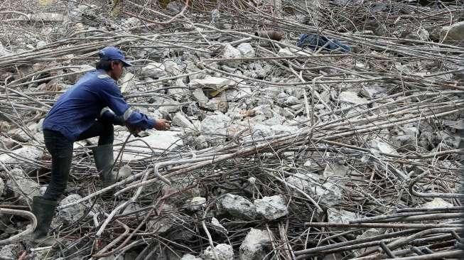 Pekerja menggunakan alat berat membongkar bangunan Pasar Rumput, di Jakarta, Senin (17/10/2016). [Suara.com/Oke Atmaja]