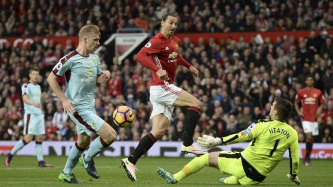 Penjaga gawang Burnley, Tom Heaton menghalau bola sepakan striker MU, Zlatan Ibrahimovic dalam laga Liga Primer, Sabtu (29/10) [AFP/Oli Scarff].