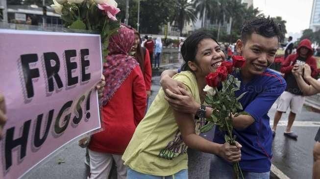 Pengunjung ajang Car Free Day (FCD) melakukan aksi berpelukan secara gratis di Bundaran HI, Jakarta (13/11/2016). [Suara.com/Kurniawan Mas'ud]