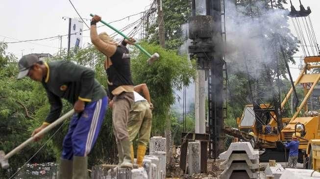 Sejumlah pekerja tampak menyelesaikan proyek pemancangan turap di sepanjang Kali Roxy, Jakarta, Senin (14/11/2016). [Suara.com/Kurniawan Mas'ud]