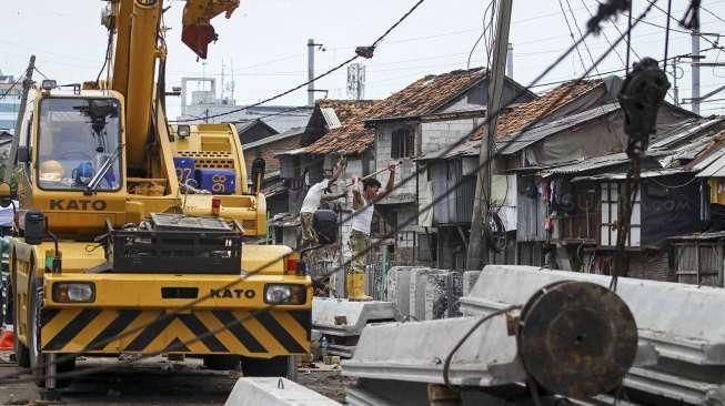 Sejumlah pekerja tampak menyelesaikan proyek pemancangan turap di sepanjang Kali Roxy, Jakarta, Senin (14/11/2016). [Suara.com/Kurniawan Mas'ud]