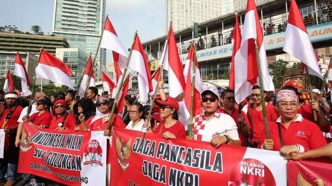 Peserta membentangkan bendera Merah Putih raksasa saat mengikuti Karnaval Cinta Budaya NKRI di kawasan Bunderan HI, Jakarta, Minggu (20/11/2016). [Suara.com/Oke Atmaja]