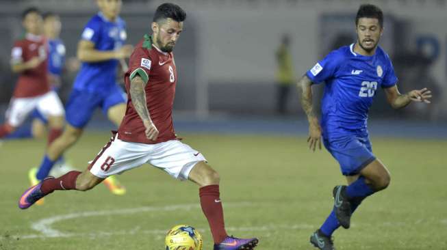 Pemain Indonesia Stefano Lilipaly (kiri) melepaskan tembakan dengan dihadang pesepak bola Filipina Jeffrey Mallen Christiaens pada putaran final Grup A AFF Suzuki 2016 di Philippinne Sport Stadium, Bocaue, Bulacan, Filipina, Selasa (22/11). [Antara]