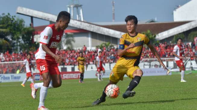 Pesepak bola Mitra Kukar FC Dedy Gusmawan (kanan) berebut bola dengan pesepak bola PSM Makassar Ridwan Tawainela (kiri) dalam pertandingan TSC 2016, (27/11) [Antara/Dewi Fajriani]