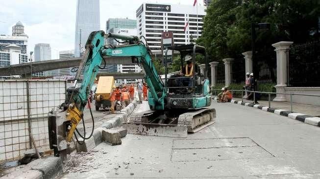 Petugas Pemeliharaan Prasarana dan Sarana Umum (PPSU) membuat jalur air di kawasan Jalan Jenderal Sudirman, Jakarta, Sabtu (3/12/2016). [Suara.com/Oke Atmaja]