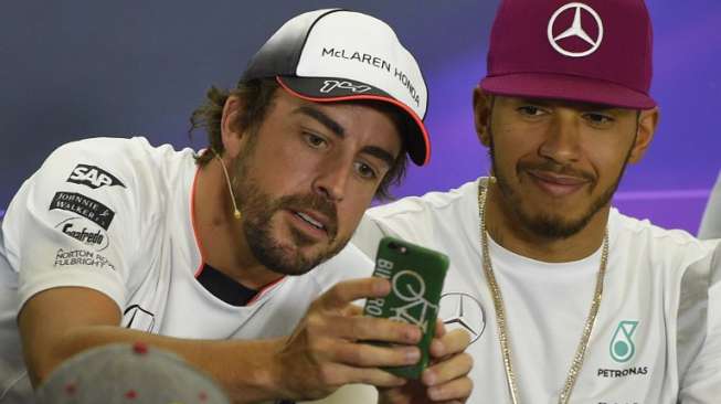 Pebalap McLaren-Honda, Fernando Alonso (kiri), meminta "wefie" Lewis Hamilton (Mercedes) dengan kamera telepon selulernya [AFP/Lluis Gene]