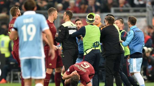 Gelandang AS Roma, Kevin Strootmann, terjatuh ke tanah usai didorong pemain Lazio, Danilo Cataldi, saat kedua tim bertemu, Minggu (4/12/2016) [AFP/Alberto Pizzoli]