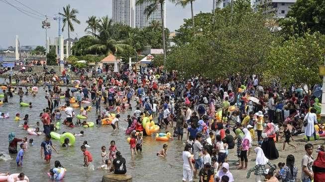 Pengunjung dari berbagai daerah memadati Pantai Festival di kawasan wisata Taman Impian Jaya Ancol, Jakarta, Minggu (25/12/2016). [Suara.com/Kurniawan Mas'ud]