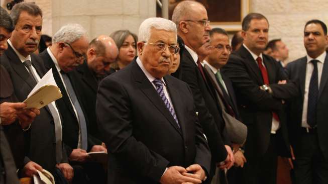 Presiden Palestina, Mahmoud Abbas (tengah), saat menghadiri Misa Natal di Gereja Saint Catherine di Bethlehem, Tepi Barat, Minggu (25/12/2016). [Musa Al Shaer/AFP Pool/AFP]