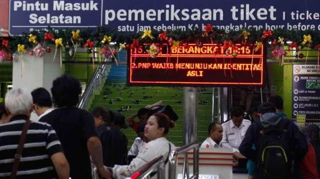 Sejumlah calon penumpang kereta api menunggu, sementara yang lainnya antre menuju peron keberangkatan di Stasiun Gambir, Jakarta, Senin (26/12/2016). [Suara.com/Oke Atmaja]