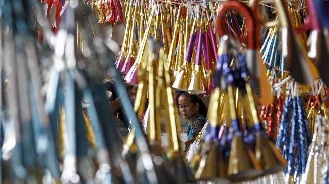 Pedagang terompet musiman menyelesaikan pembuatan terompet di kawasan Kota Tua, Jakarta, Selasa (27/12/2016). [Suara.com/Kurniawan Mas'ud]