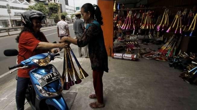 Pedagang terompet musiman menyelesaikan pembuatan terompet di kawasan Kota Tua, Jakarta, Selasa (27/12/2016). [Suara.com/Kurniawan Mas'ud]