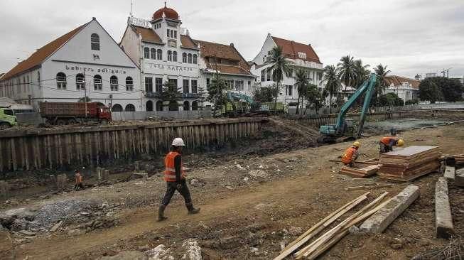 Sejumlah pekerja menyelesaikan proyek revitalisasi sungai di kawasan wisata Kota Tua, Jakarta, Rabu (28/12/2016). [Suara.com/Kurniawan Mas'ud]