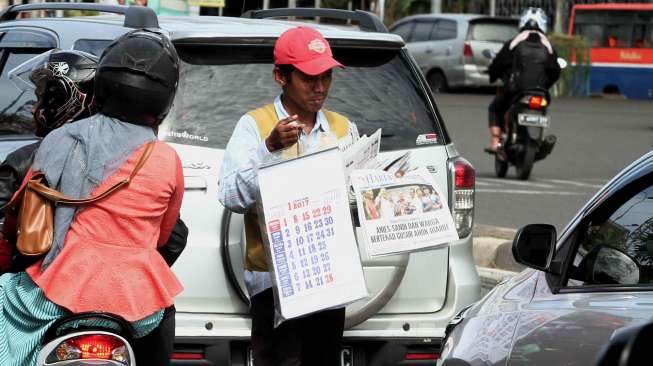 Penjual Kalender dikawasan Senen, Jakarta, Kamis (29/12). Untuk kalender ukuran besar dijual dengan harga Rp 30.000, dan Rp 10.000 untuk kalender berukuran kecil [Suara.com/Oke Atmaja]