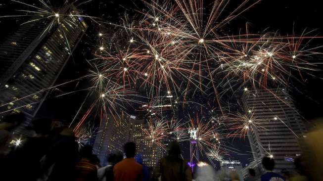 Warga Jakarta menyalakan kembang api menyambut tahun baru 2017 di kawasan Bundaran HI, Jakarta, Minggu (1/1/2017).[suara.com/Kurniawan Mas'ud]