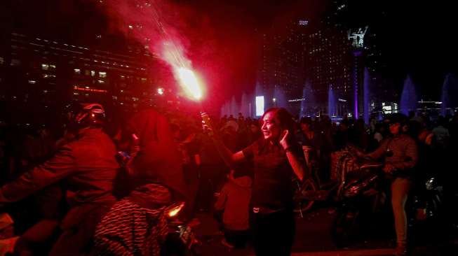 Warga Jakarta menyalakan kembang api menyambut tahun baru 2017 di kawasan Bundaran HI, Jakarta, Minggu (1/1/2017).[suara.com/Kurniawan Mas'ud]