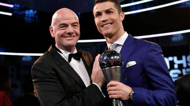 Pemain Real Madrid Cristiano Ronaldo dengan trophy Pemain Pria Terbaik FIFA 2016 berpose dengan Presiden FIFA Gianni Infantino. Fabrice COFFRINI / AFP