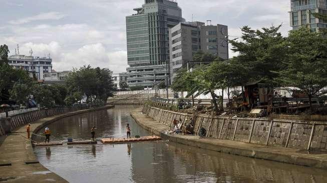 Petugas UPK Badan Air Taman Jalur Hijau Provinsi DKI Jakarta membersihkan sampah yang terbawa oleh aliran Kali Kwitang, di Jakarta, Kamis (12/1).