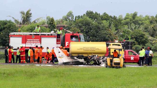 Sejumlah petugas mengevakuasi bangkai pesawat latih yang gagal landing di Bandara Blimbingsari, Banyuwangi, Jawa Timur, Senin (16/1).