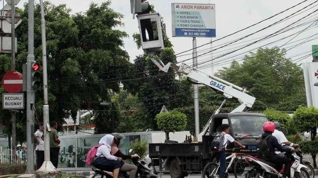 Petugas memperbaiki lampu lalu lintas di kawasan Rawamangun, Jakarta, Rabu (18/1/2017). [Suara.com/Oke Atmaja]