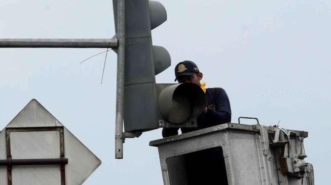 Petugas memperbaiki lampu lalu lintas di kawasan Rawamangun, Jakarta, Rabu (18/1/2017). [Suara.com/Oke Atmaja]