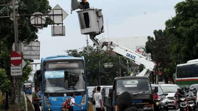 Petugas memperbaiki lampu lalu lintas di kawasan Rawamangun, Jakarta, Rabu (18/1/2017). [Suara.com/Oke Atmaja]