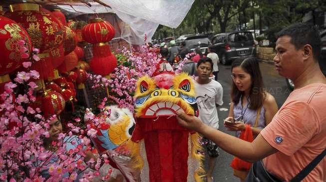 Para pedagang menjajakan pernak-pernik perayaan Imlek kepada calon pembeli di Jalan Pancoran Raya, Glodok, Jakarta, Rabu (18/1/2017). [Suara.com/Kurniawan Mas'ud]