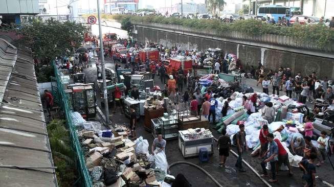 Petugas berusaha memadamkan api yang membakar kios di bangunan Blok I dan Blok II Pasar Senen di Jakarta, Kamis (19/1).