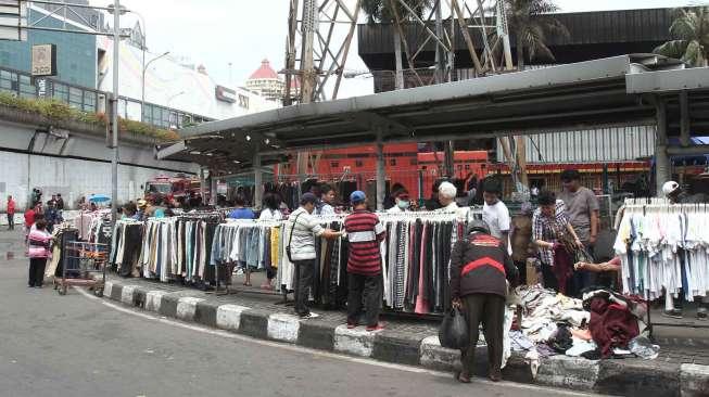 Sejumlah pedagang pakaian berjualan di trotoar dan memberikan diskon.