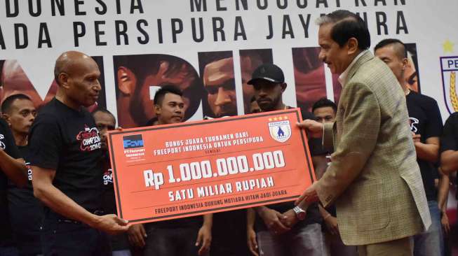 Presdir PT Freeport Indonesia Chappy Hakim (kanan) menyerahkan bonus secara simbolis kepada Ketua Umum Persipura Jayapura Benhur Tomi Mano (kedua kiri) disaksikan pemain dan ofisial Klub Persipura Jayapura di Jakarta, Jumat (6/1). [Antara]