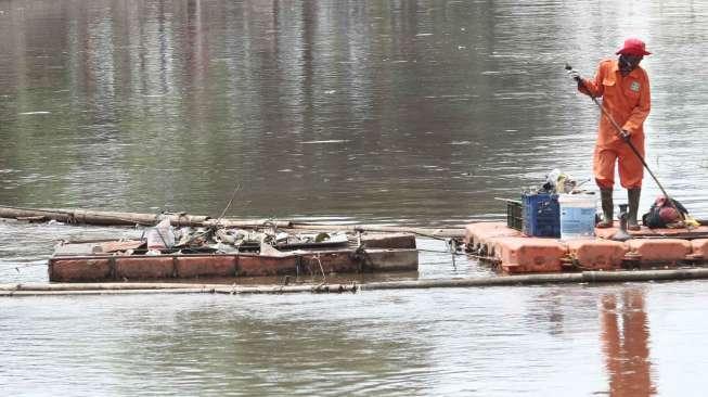 Petugas Pemelihara Prasarana dan Sarana Umum (PPSU) DKI atau yang sering disebut pasukan oranye, membersihkan sungai di kawasan Kwitang, Jakarta Pusat, Selasa (24/1).