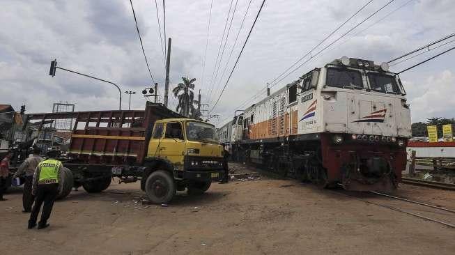 Petugas mengevakuasi sebuah truk bak terbuka yang tertabrak kereta api Cirebon Express di perlintasan depan LP Cipinang, Jakarta, Rabu (25/1).