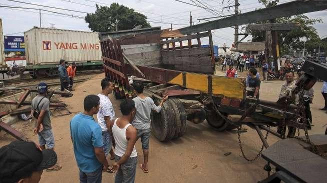 Petugas mengevakuasi sebuah truk bak terbuka yang tertabrak kereta api Cirebon Express di perlintasan depan LP Cipinang, Jakarta, Rabu (25/1).