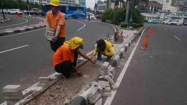 Sejumlah pekerja Suku Dinas Jakarta Pusat melakukan perbaikan separator (pembatas jalur) di Jalan M.H. Thamrin, kawasan Bundaran Hotel Indonesia, Jakarta, Jumat (27/1).