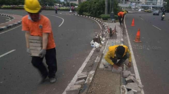 Sejumlah pekerja Suku Dinas Jakarta Pusat melakukan perbaikan separator (pembatas jalur) di Jalan M.H. Thamrin, kawasan Bundaran Hotel Indonesia, Jakarta, Jumat (27/1).