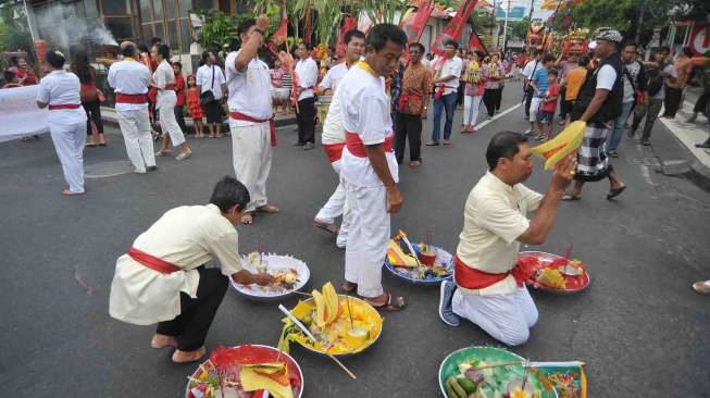 Sejumlah umat menggelar ritual tolak bala Imlek 2568 di Jalan Raya Kawasan Kuta, Bali, Jumat (27/1).